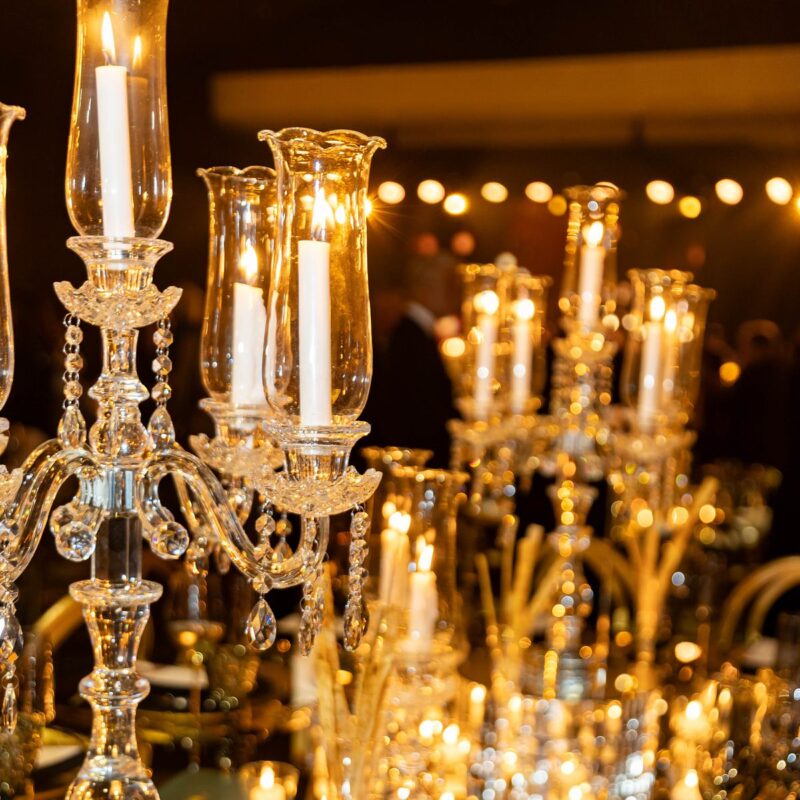 Candelabros y velas en las mesas de la gala Adopte Una Cuna 2026