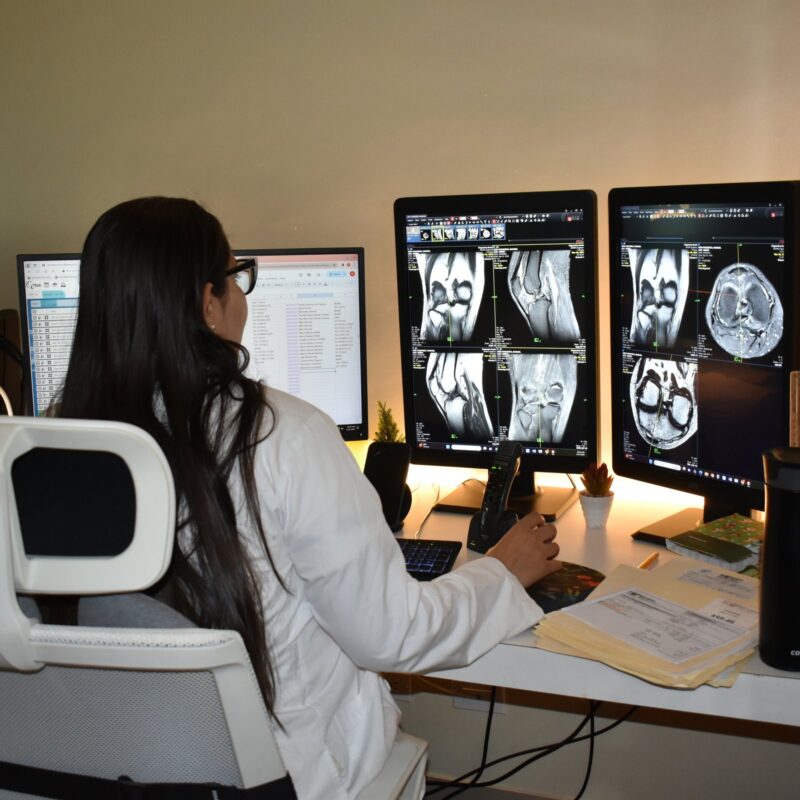 Médica radióloga revisa imágenes de resonancia magnética