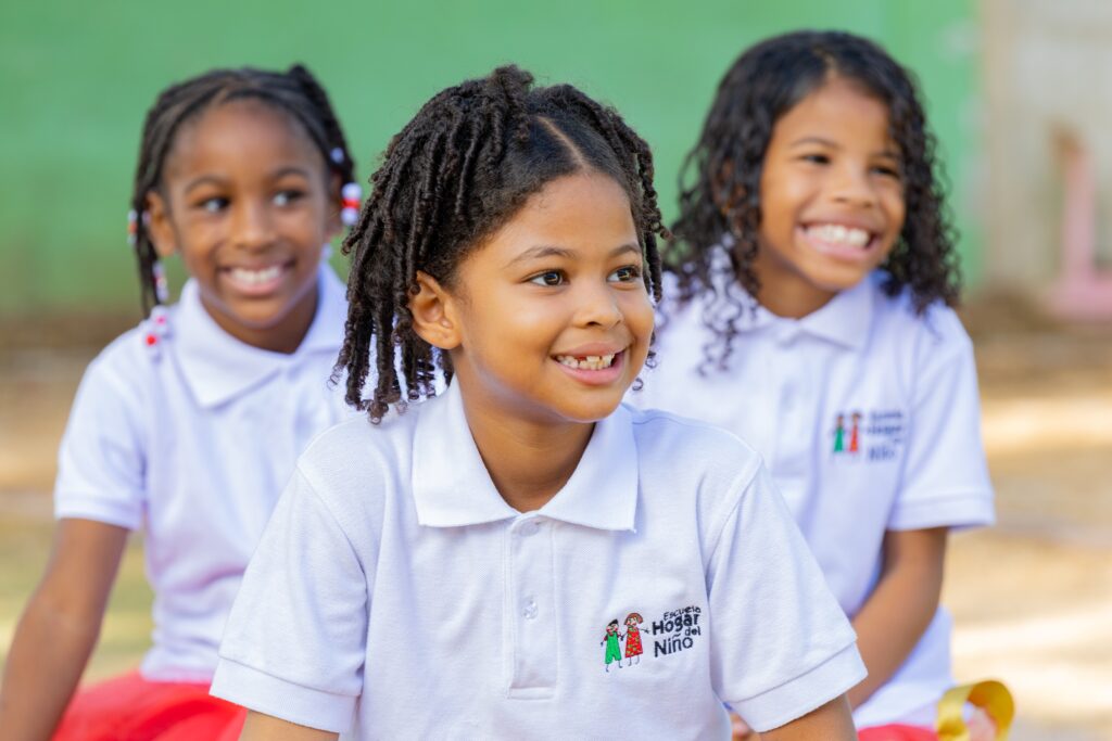 Niñas sonrientes con el uniforme de la Escuela Hogar del Niño
