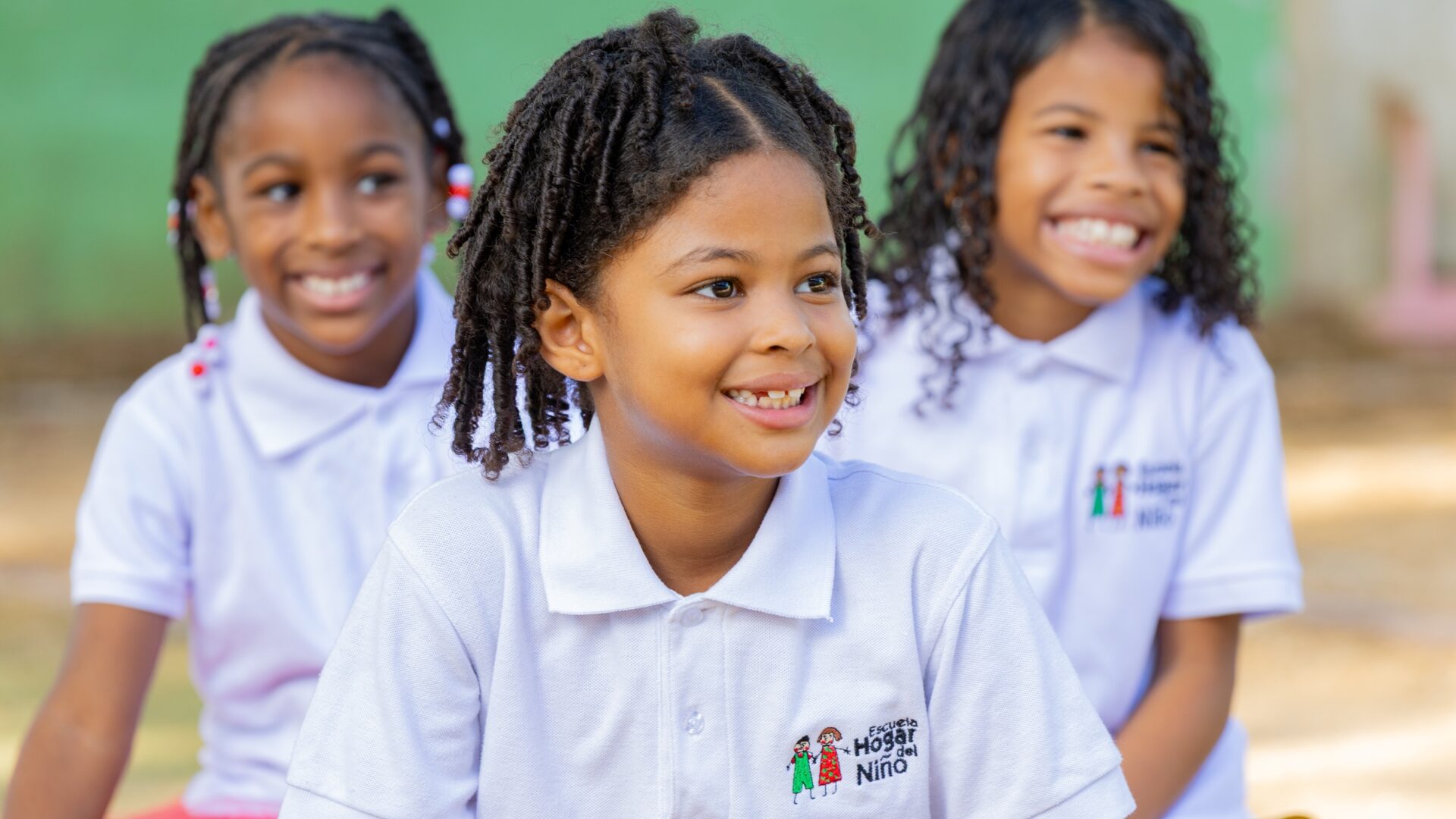 Niñas sonrientes con el uniforme de la Escuela Hogar del Niño