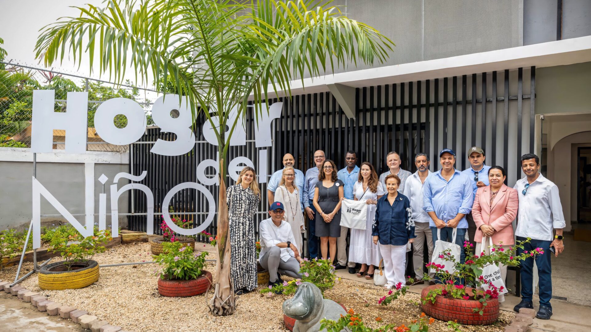 Delegación de embajadores de la ONU frente al rótulo de la Escuela Hogar del Niño
